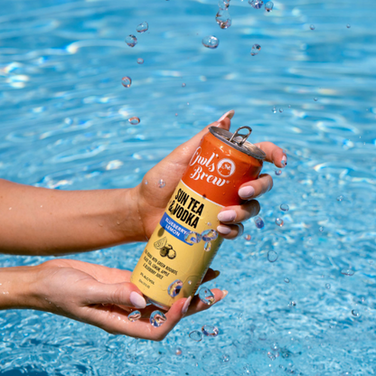 Can of Sun Tea Vodka being held over water